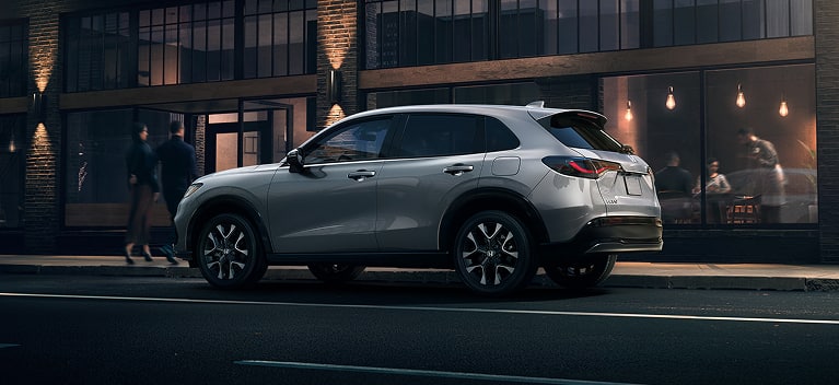 2027 Honda HR-V EX-L in Solar Silver Metallic profile parked on a city street at night (Subcompact Crossover SUV).